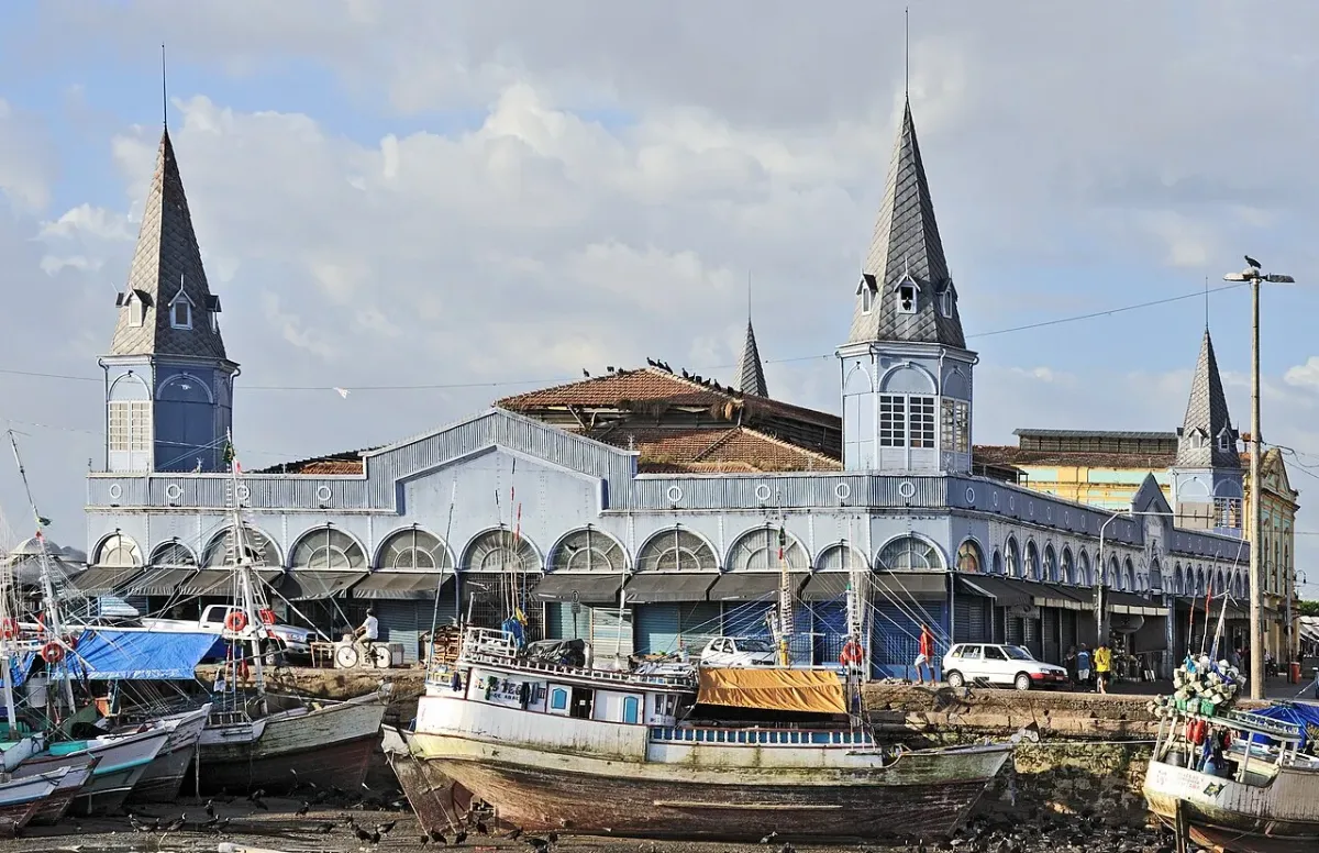 Fachada azul do mercado Ver-o-Peso, em Belém, com barcos de pesca em primeiro plano, em foto ilustrativa