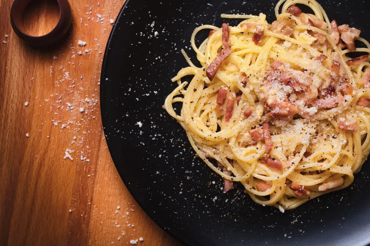 Prato de espaguete à carbonara com pancetta e queijo ralado, em foto ilustrativa que não é do restaurante