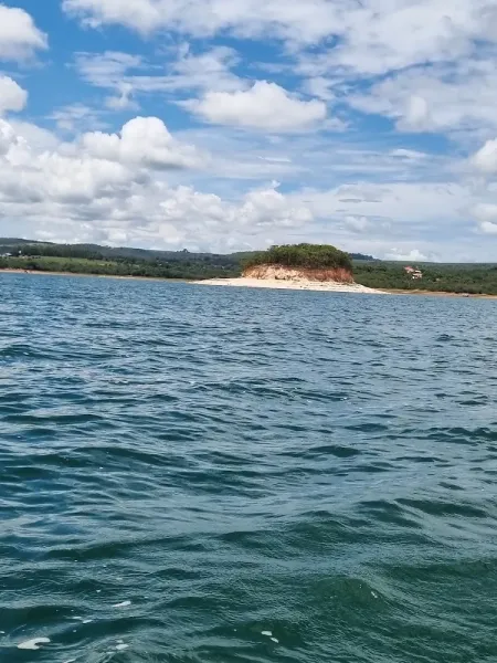A ilha vista da água, com a faixa de areia clara