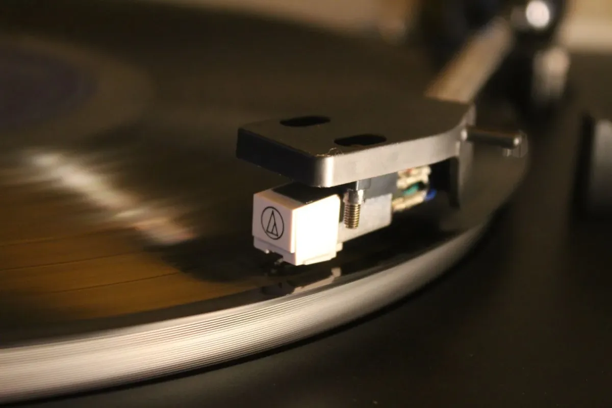 Agulha de toca-discos sobre um disco de vinil em rotação, em foto ilustrativa