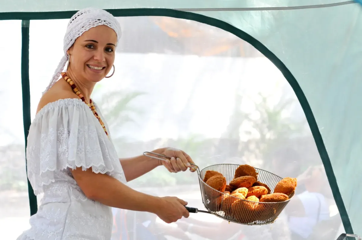 Baiana prepara acarajé em tenda: imagem ilustrativa da culinária afro-brasileira. Foto: Fonseca001/Wikimedia Commons (domínio público)