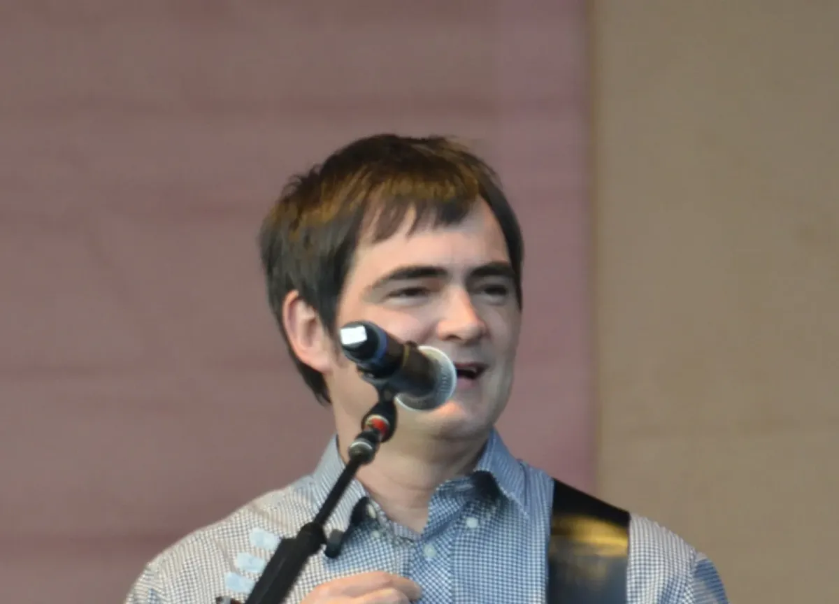 Samuel Rosa cantando ao microfone com guitarra a tiracolo, em foto de arquivo de 2014