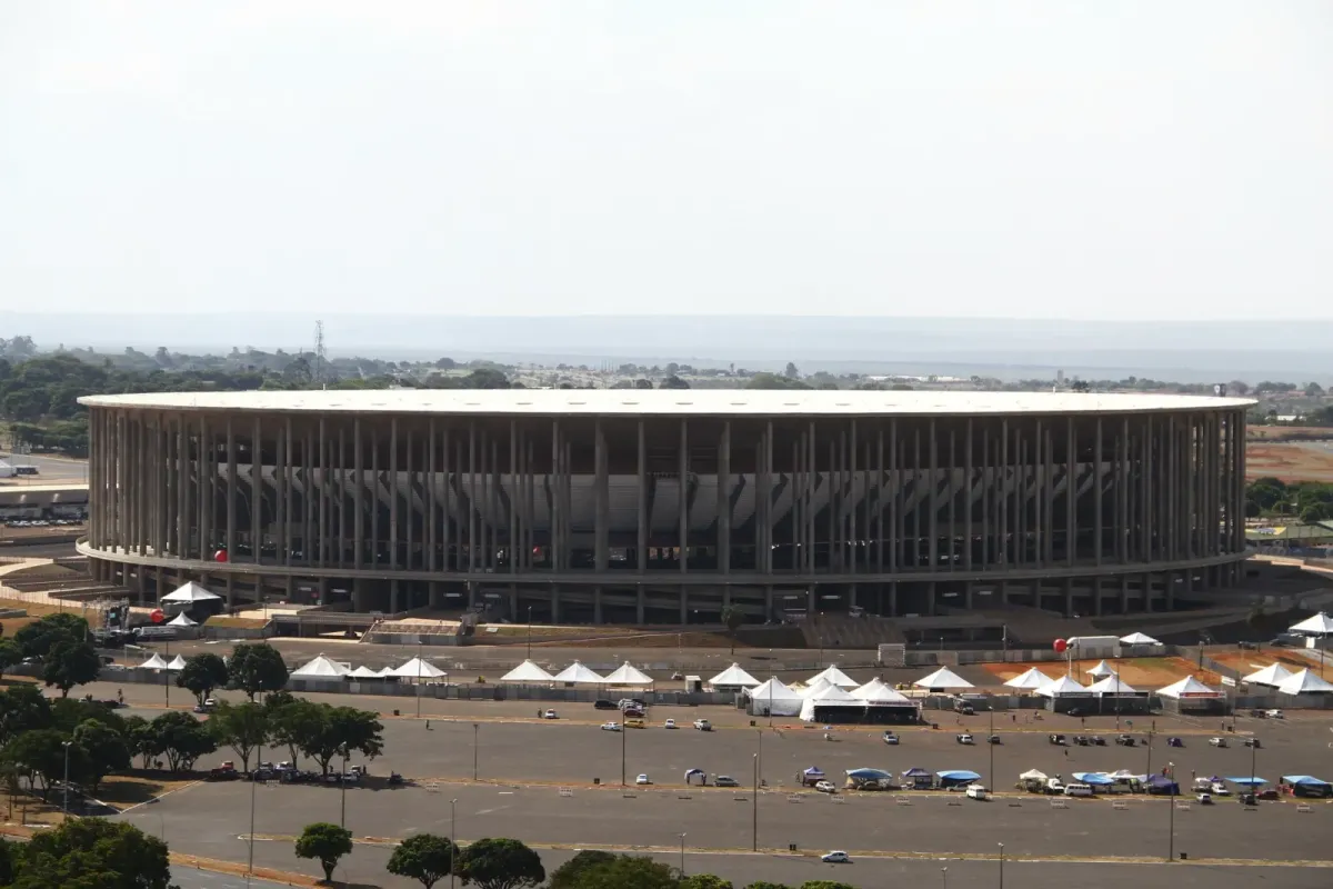 Estádio Nacional Mané Garrincha visto de cima, com tendas brancas no estacionamento