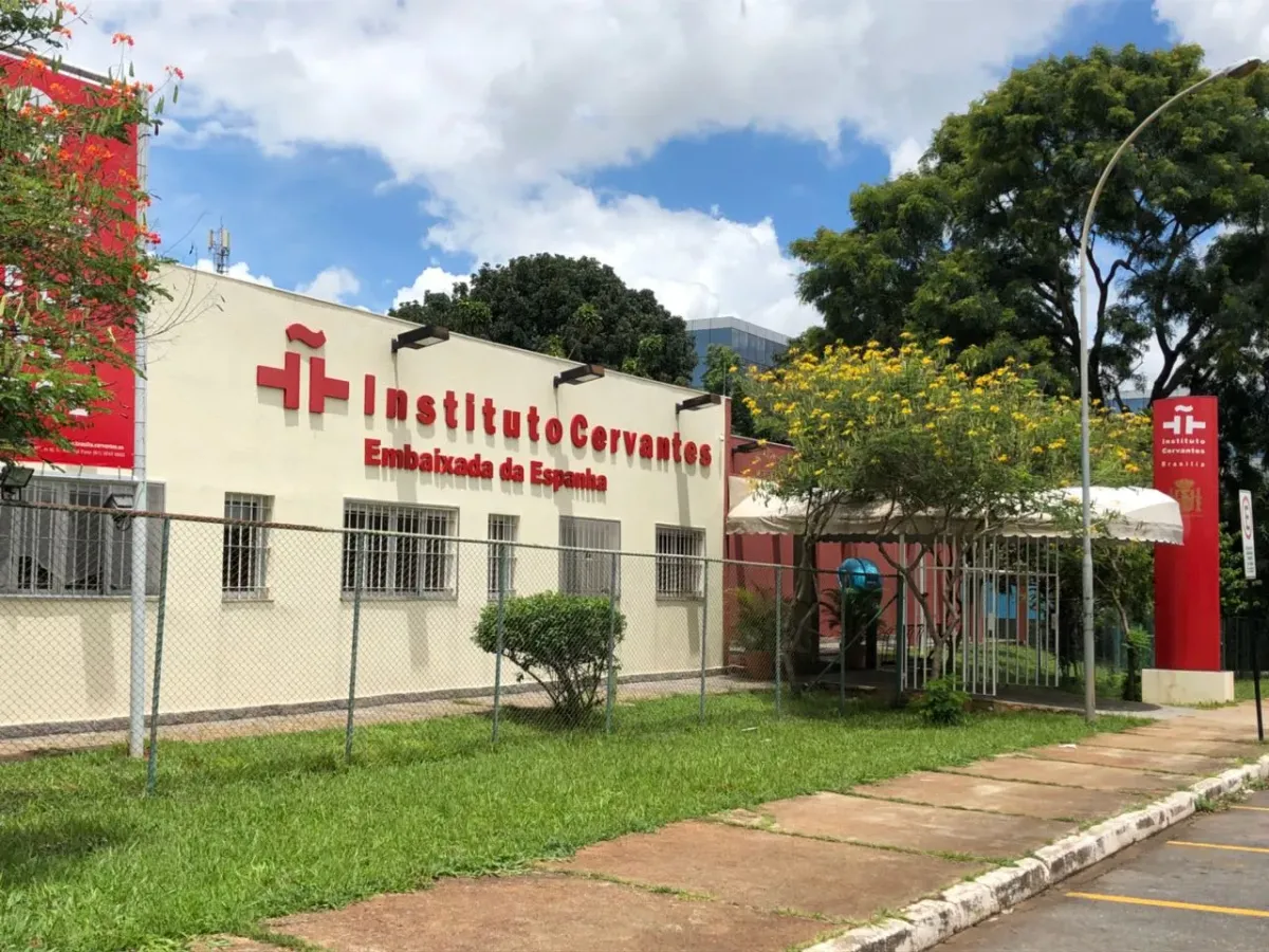 Fachada do Instituto Cervantes de Brasília, com letreiro vermelho e a bandeira da Embaixada da Espanha